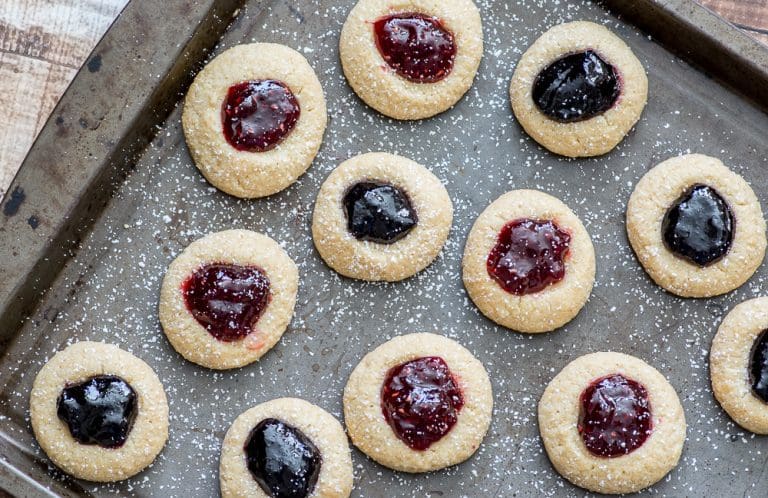Only 6 ingredients to these melt-in-your-mouth holiday cookies. These Gluten free Jam Thumbprint Cookies are tender, buttery and generously filled with your favorite choice of jam!! Yum!