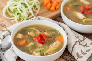 Healthy, low carb, paleo and gluten free alternative to regular chicken noodle soup. Kick it up a notch with the addition of soy sauce, ginger and a little chili pepper. Even if you don't usually like zucchini, you will LOVE this recipe!