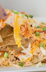 Loaded Buffalo Chicken Nachos. Shredded buffalo chicken, creamy cheese sauce, blue cheese crumbles and chopped green onions make these nachos the ultimate game day appetizer!