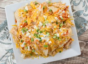 Loaded Buffalo Chicken Nachos. Shredded buffalo chicken, creamy cheese sauce, blue cheese crumbles and chopped green onions make these nachos the ultimate game day appetizer!